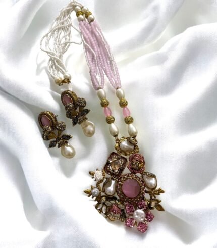 Gold-plated necklace with pink crystals, pearls, and floral accents, paired with matching earrings.