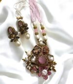 Gold-plated necklace with pink crystals, pearls, and floral accents, paired with matching earrings.
