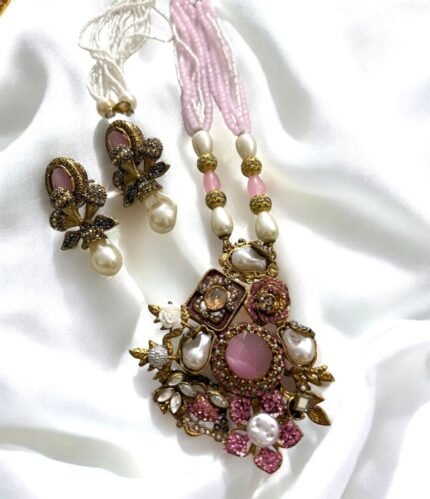 Gold-plated necklace with pink crystals, pearls, and floral accents, paired with matching earrings.