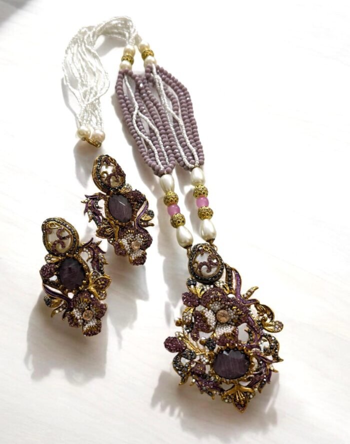 Lavender crystal and pearl necklace with floral pendant, paired with matching earrings.