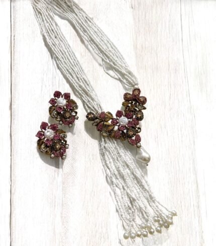Gold-plated necklace with pink crystals, pearls, and floral accents, paired with matching earrings.