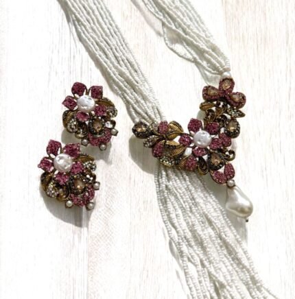 Gold-plated necklace with pink crystals, pearls, and floral accents, paired with matching earrings.