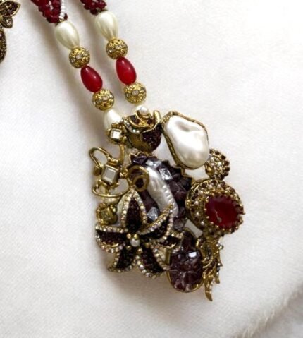 Gold-plated necklace with red beads, pearls, and gemstone embellishments, paired with matching earrings.