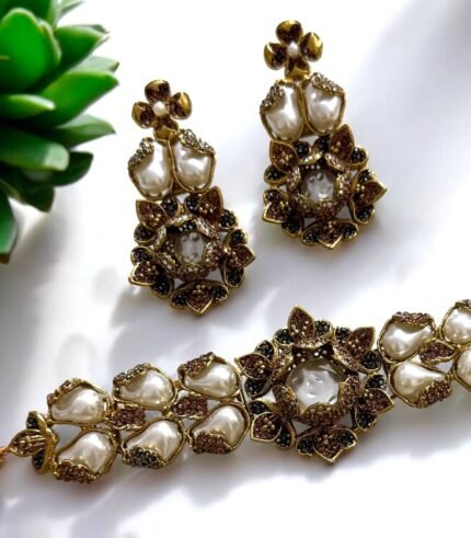 Gold necklace and earrings set with pearls and crystal embellishments in a floral design.