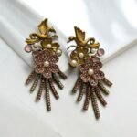 Gold earrings with a bird and flower design, decorated with pearls and crystals.