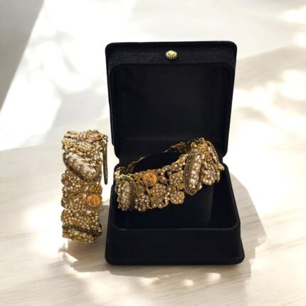 Gold-plated bracelets adorned with pearls and floral embellishments, presented in a black gift box.
