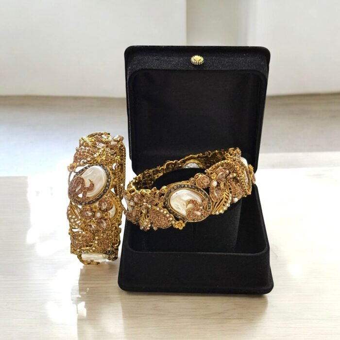 Gold-plated bracelets with pearls, rose gold accents, and intricate crystal details.