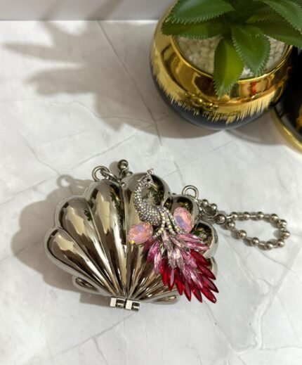 Silver clutch with a pink and red crystal peacock design, featuring a detachable chain strap.