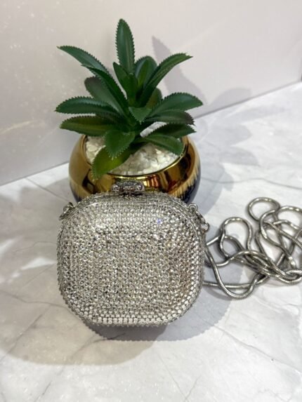 Silver crystal-embellished clutch with a detachable silver chain strap.