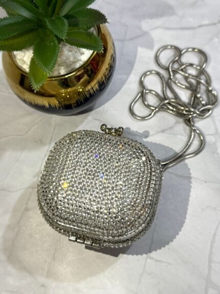 Silver crystal-embellished clutch with a detachable silver chain strap.