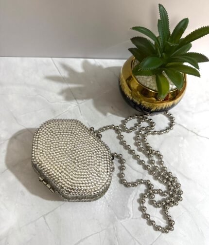 Silver crystal-embellished clutch with a detachable silver chain strap.