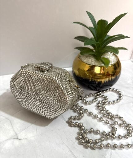 Silver crystal-embellished clutch with a detachable silver chain strap.