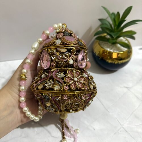 Pink potli clutch with gemstones, pearls, and antique gold floral design